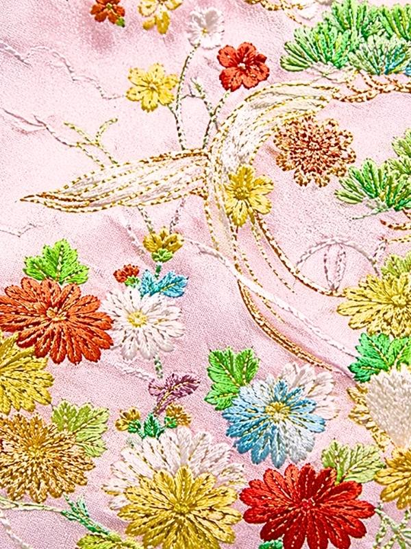 御所解き文様の刺繍部分を拡大した着物生地、色鮮やかな草花と金糸の繊細な刺繍